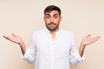 Wall Mural - Handsome man with beard over isolated background having doubts with confuse face expression