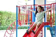 Asian Child Cute Or Kid Girl Smiling Playing Slider And Happy Fun Or Cheerful Enjoy With Extend Arms On Holiday Relax Exercise At Playground Public Park In Kids Club Or Nursery Kindergarten And School