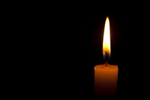 Horizontal Photo Of Lighted Candle Isolated On Black Background. Copy Space. Close Up.