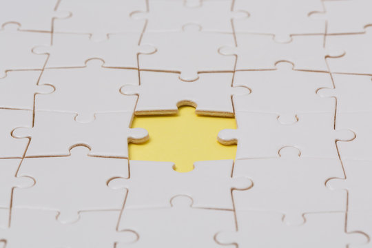 Fototapete - Jigsaw puzzle with one piece missing, yellow background