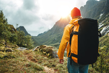brave tourist wearing yellow jacket with travel backpack hiking in mountains outdoor journey. active