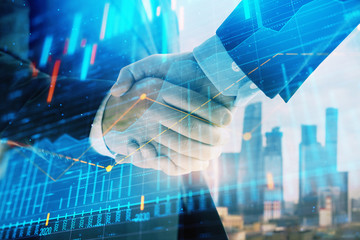 Double exposure of financial graph on cityscape background with two businessman handshake. Concept of stock market deal