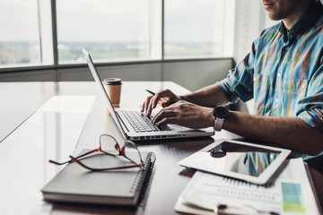 Businessman working on computer. Men using laptop and digital tablet in the office. Internet marketing, finance, business concept