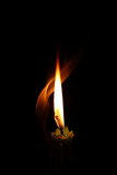 Fototapeta  - One light candle burning brightly in the black background.