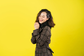 asian woman, she is happy. she is with a yellow background.
