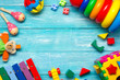 © Roman Motizov - Colorful kids toys frame on wooden background. Top view. Flat lay. Copy space for text.