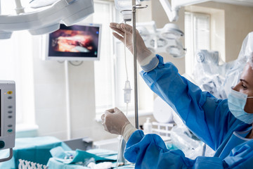 Wall Mural - Medical drip tubing and patient at the hospital.