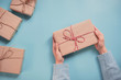 © oatawa - Woman Hands holding craft paper gift box on blue background. for present Christmas, new year, valentine day or anniversary.