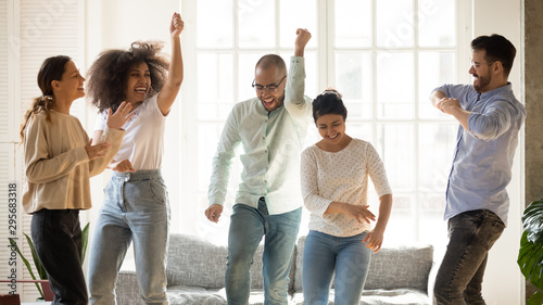 Cuadros en Lienzo Happy diverse friends dancing at home party, having fun
