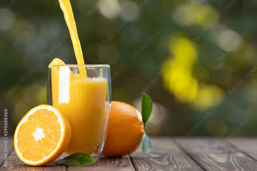 orange juice pouring in glass - obrazy, fototapety, plakaty 