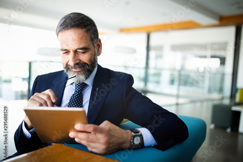 Cuadros en Lienzo Elegant business multitasking multimedia man using devices