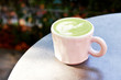 Ceramic cup of matcha latte with beautiful foam on grey background.