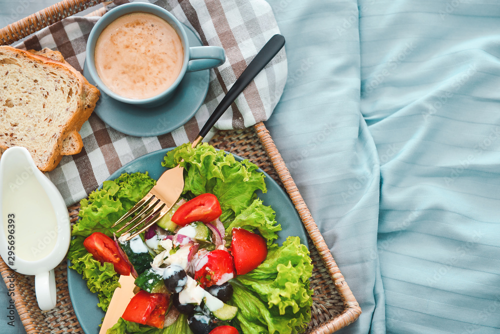 Tray with tasty breakfast on bed