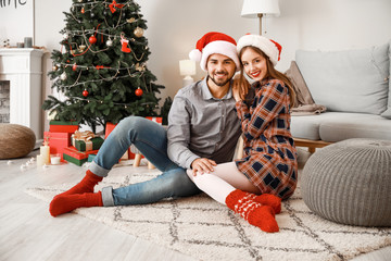 Happy young couple celebrating Christmas at home