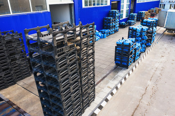 Wall Mural - Aerial view of freight warehouse of drinking water plant or factory, racks with plastic bottles or gallons ready for loading at trucks