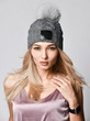 Outdoor portrait of a young beautiful fashionable lady wearing stylish knitted hat.