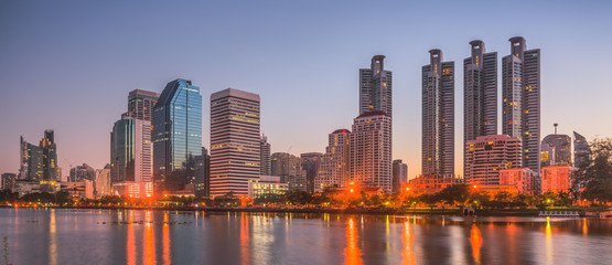 Wall Mural - Lake in City Park under Skyscrapers at Twilight. Benjakiti Park in Bangkok, Thailand