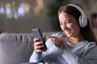 © Antonioguillem - Happy woman listening to music with headphones and smartphone