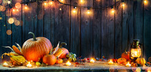 Thanksgiving - Pumpkins On Rustic Table With Candles And String Lights 
