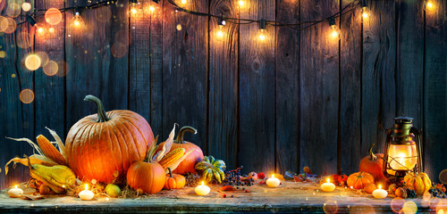 thanksgiving - pumpkins on rustic table with candles and string lights