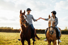 Portrait Of Happy Loving Couple Spending Time With Horses On Ranch