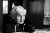 Fototapeta  - Portrait of a lonely sad old lady. Black and white photo.