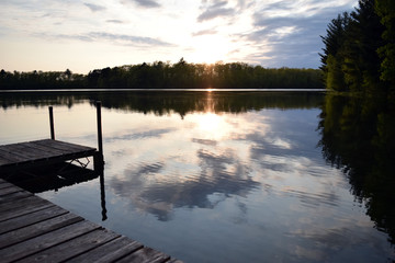  Sunset over a lake with a dock on the side.
