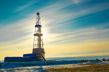 Wall Mural - Oil and gas drilling rig in the northern tundra. The beginning of winter in the Arctic. The sun sparkles through the oil derrick.