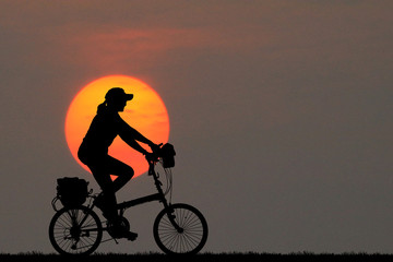 Wall Mural - Silhouette  Cycling  on blurry sunrise  sky   background.