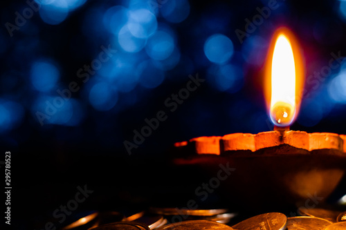 Low Angle Close Up Shot Of An Earthen Lamp On A Pile Of Coins