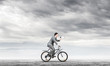 © adam121 - Businessman with megaphone on bike