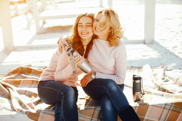 Wall Mural - young blonde mom with her grown up daughter in the spring park