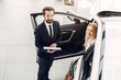 © prostooleh - Woman buying the car. Lady in a car salon. Manager with a client