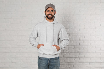 Wall Mural - Portrait of young man in sweater at brick wall. Mock up for design