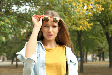 Canvas Print - Young woman wearing stylish sunglasses in park