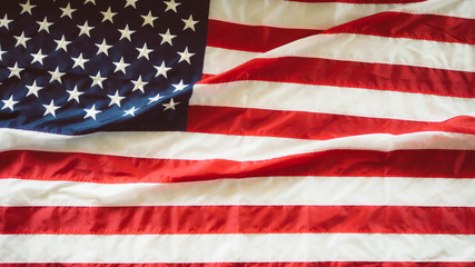 American flag waving in the wind with blue sky and is a symbol of peace.