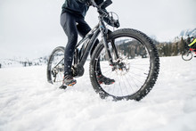 Midsection Of Mountain Biker Riding In Snow Outdoors In Winter.