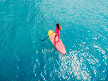 Attractive Woman On Stand Up Paddle Board On A Quiet Blue Ocean. Sup Surfing In Sea