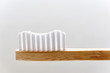 Closeup of a wooden toothbrush. Simple bamboo biodegradable eco toothbrush against a light background with copy space.