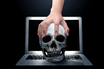 Poster - Hand holding human skull above the laptop