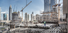 Laborers Working On Modern Constraction Site Works In Dubai. Fast Urban Development Consept.