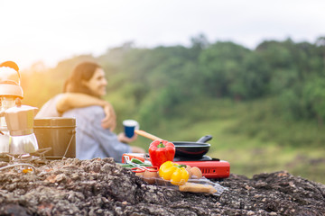 Cooking equipment coffee drinks on the slopes of a camping tent, lovers and views of green forests.