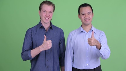 Sticker - Two happy multi ethnic businessmen giving thumbs up together