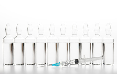 Wall Mural - Glass medicine ampoules and Syringe on white background