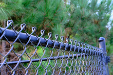 Light Falling On Top Of Black Chain Link Fence