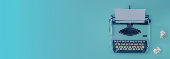 A blue vintage typewriter with blue background and paper balls.	