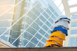 © Pornnarong - Helmet hats for safety work put on stair with city background.