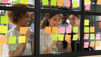 Businesspeople working on new project writing ideas using sticky notes