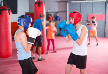 Ordinary boys and girl practicing boxing punches