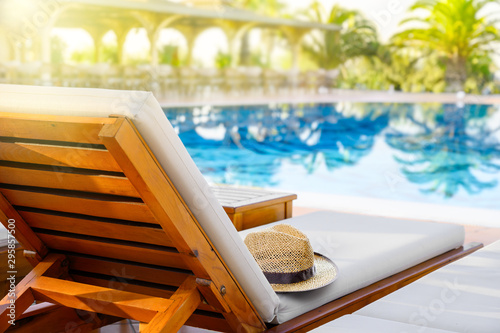 Fotomural Lounger with sun hat and swimming pool in luxury resort